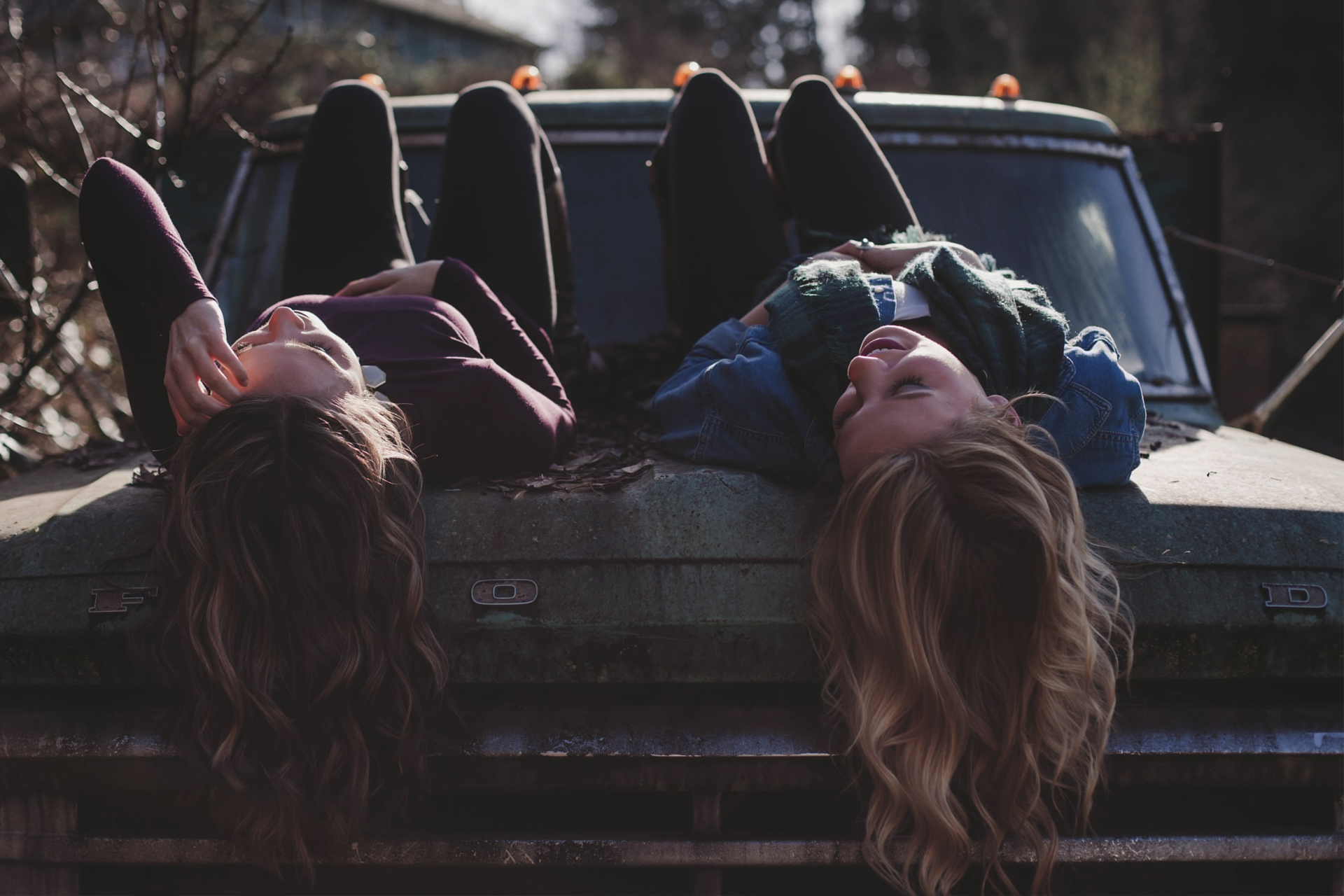 two friends lying on car bonnet